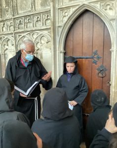 Teacher talking to a student at the front door of a cathedral