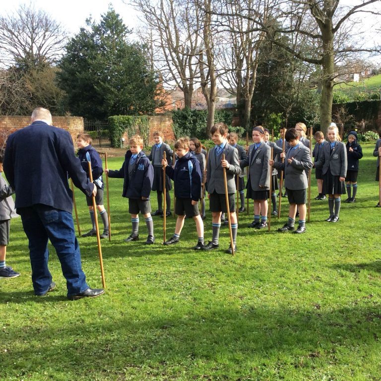 students holding sticks