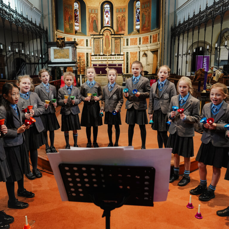 students holding bells to ring